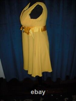 Olivia DeHavilland gold short sleeve dress withsash from Sydney Guilaroff