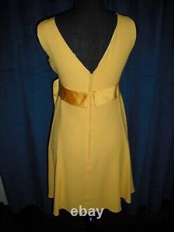 Olivia DeHavilland gold short sleeve dress withsash from Sydney Guilaroff